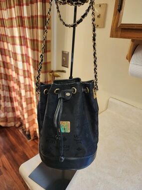 black vintage MCM Visetos canvas bucket bag featuring a gold chain strap